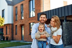 Arlington apartment for rent - A family of three stands in front of a modern house.