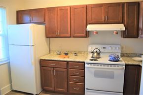 Arlington apartment for rent - A kitchen with brown cabinets and a white stove.
