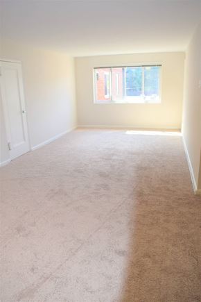 Arlington apartment for rent - A room with a carpeted floor and a window letting in light.