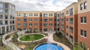 Arlington apartment for rent - A large building with a pool in the middle of a courtyard.