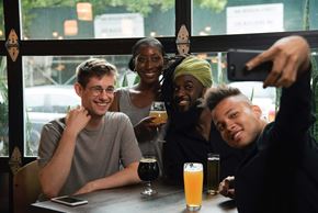 Baltimore apartment for rent - Four people are sitting at a table with drinks and taking a selfie.