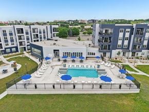 Madison apartment for rent - A large swimming pool surrounded by lounge chairs and umbrellas in the middle of a grassy area.