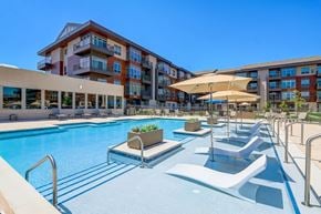 Verona apartment for rent - a swimming pool with lounge chairs and umbrellas in front of a hotel