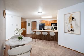 Fargo apartment for rent - A white marble table with a vase of white flowers on it sits in a kitchen. Fargo, ND Cedars 4 Apartments