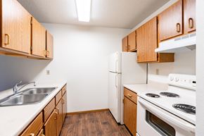Fargo apartment for rent - A kitchen with wooden cabinets and white appliances. Fargo, ND Candlelight Apartments