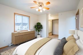 Fargo apartment for rent - A bedroom with a large bed and a ceiling fan. Fargo, ND Summit Point Apartments