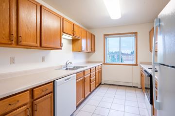 Fargo apartment for rent - A kitchen with wooden cabinets and a white dishwasher.
