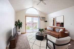 Fargo apartment for rent - A living room with a brown couch, a television, and a plant. Fargo, ND Summit Point Apartments