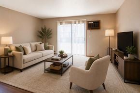 Fargo apartment for rent - A living room with a white sofa, a white chair, a coffee table, and a flat screen TV.