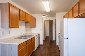 Dilworth apartment for rent - A kitchen with wooden cabinets and a white fridge. Fargo, ND Fieldstone Apartments
