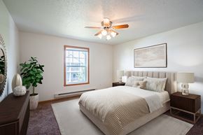 Fargo apartment for rent - A bedroom with a large bed and a ceiling fan. Fargo, ND Stonebridge Apartments