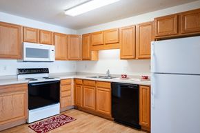 Fargo apartment for rent - A kitchen with wooden cabinets and a white refrigerator. Fargo, ND Stonebridge Apartments