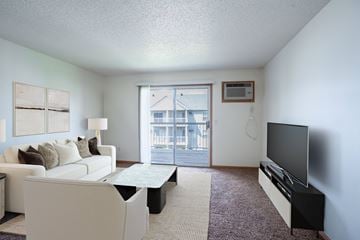 Fargo apartment for rent - A living room with a white couch and a flat screen TV.