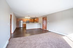 Fargo apartment for rent - A kitchen with wooden cabinets and a refrigerator is visible. Fargo, ND Urban Plains Apartments