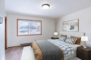 Fargo apartment for rent - A bedroom with a large bed and a window overlooking a snowy street.  Fargo, ND Carr Apartments