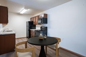 Moorhead apartment for rent - A black table with a vase on it sits in the middle of a kitchen. Moorhead, MN Woodstone Apartments