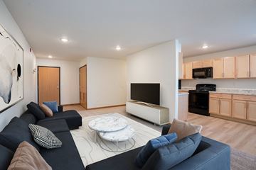 Grand Forks apartment for rent - A modern living room with a black couch and a white coffee table.