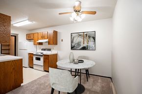 Fargo apartment for rent - A kitchen with a table and chairs and a framed picture on the wall. Fargo, ND Countryside Apartments