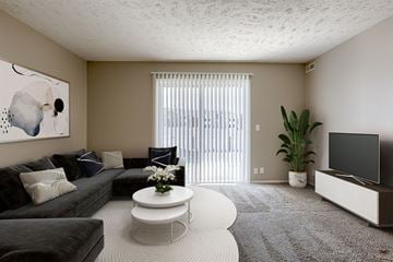 Omaha apartment for rent - A living room with a grey couch, a white coffee table, and a painting on the wall.