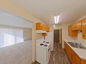 Crookston apartment for rent - A kitchen with white appliances and wooden cabinets.