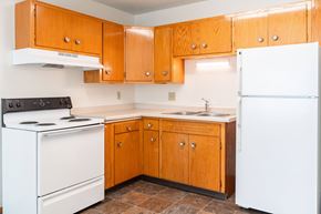 Fargo apartment for rent - A kitchen with wooden cabinets and a white refrigerator. Fargo, ND Morningside Apartments