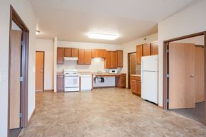 Fargo apartment for rent - A kitchen with brown cabinets and a white refrigerator. Fargo, ND North Sky II Apartments
