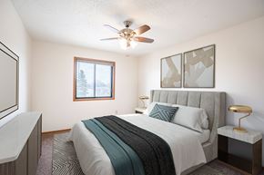 Fargo apartment for rent - A bedroom with a bed, nightstand, and window. Fargo, ND Hawthorn Apartments