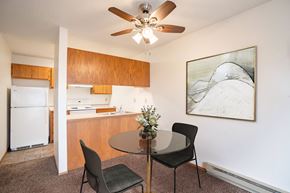 Fargo apartment for rent - A kitchen with a table and chairs and a ceiling fan. Fargo, ND Hawthorn Apartments