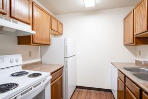 Fargo apartment for rent - A kitchen with a white stove and a white refrigerator. Fargo, ND Summerfield Apartments