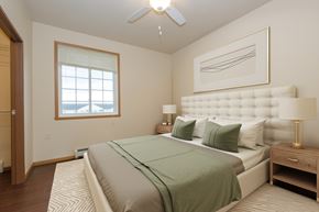 Fargo apartment for rent - A bedroom with a large bed and a ceiling fan.