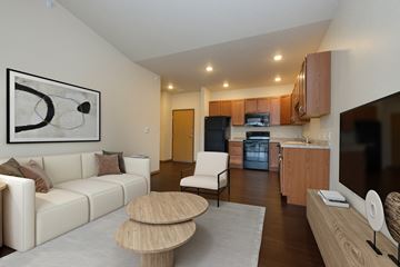 Fargo apartment for rent - A modern living room with a white couch, wooden coffee table, and a painting on the wall.