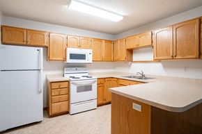 Fargo apartment for rent - A kitchen with wooden cabinets and white appliances. Fargo, ND Crown Court 2 Apartments
