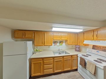 Grand Forks apartment for rent - A kitchen with wooden cabinets and white appliances.