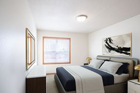 West Fargo townhouse for rent - A bedroom with a bed, nightstand, and a painting on the wall. West Fargo, ND Sheyenne Terrace Townhomes