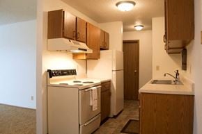 Fargo apartment for rent - a kitchen with a stove refrigerator and a sink. Fargo, ND Candlelight Apartments