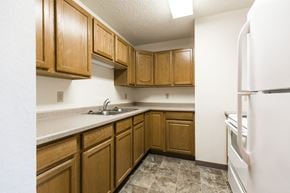 Bismarck apartment for rent - Bismarck, ND Arbor 400 Apartments. A kitchen with wooden cabinets and white appliances
