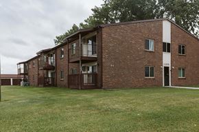 Crookston apartment for rent - Grand Forks, ND Barrette Arms Apartments. a large brick apartment building with a large grassy area in front of it