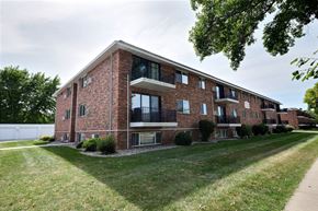 Fargo apartment for rent - a red brick apartment building with a green lawn and a sidewalk. Fargo, ND Betty Ann Apartments
