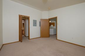 Fargo apartment for rent - a master bedroom with a closet leading to a bathroom. Fargo, ND Bridgeport Apartments