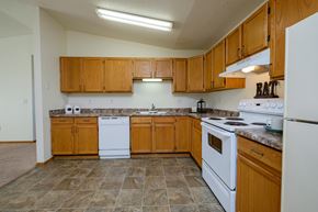 Fargo apartment for rent - a kitchen with white appliances and wooden cabinets. Fargo, ND Bridgeport Apartments