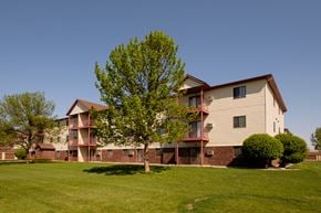 Fargo apartment for rent - the outside of a three level apartment building with two trees out front. Fargo, ND Bridgeport Apartments