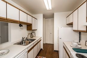 Grand Forks apartment for rent - Grand Forks, ND Bristol Park Apartments. A kitchen with white cabinets and appliances with wood floors