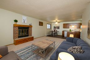 Fargo apartment for rent - Fargo, ND Cedars 2 Apartments a living room with a blue couch and a wooden coffee table in front of a fireplace