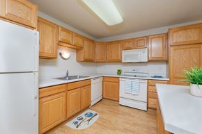 West Fargo townhouse for rent - A kitchen with white appliances and wooden cabinets