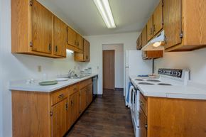 Fargo apartment for rent - a kitchen with white appliances and wooden cabinets and a white stove. Fargo, ND Countryside Apartments
