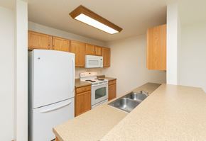 Fargo apartment for rent - a kitchen with white appliances and wooden cabinets. Fargo, ND Sunrise North
