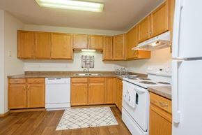 Fargo apartment for rent - a kitchen with white appliances and wooden cabinets. Fargo, ND Danbury Apartments