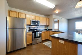 Fargo apartment for rent - a kitchen with stainless steel appliances and wooden cabinets. Fargo, ND East Bridge Apartments