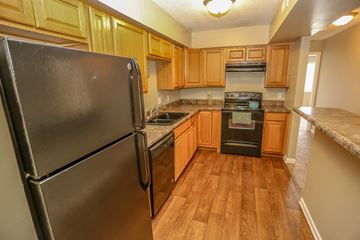 Omaha apartment for rent - a kitchen with wooden cabinets and stainless steel appliances