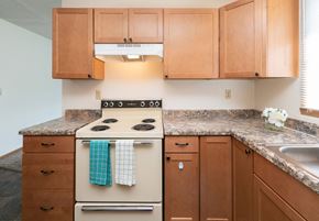 Fargo apartment for rent - a kitchen with wooden cabinets and a stove. Fargo, ND White Ridge Apartments.